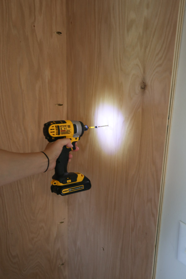 attaching built in cabinet to wall with drill and screws through wall stud