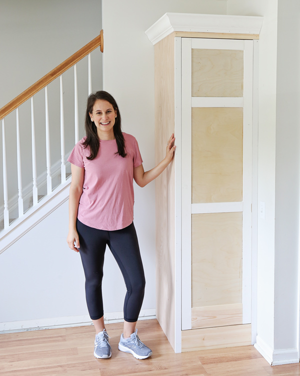 DIY built in cabinet with door before paint and woman woodworker