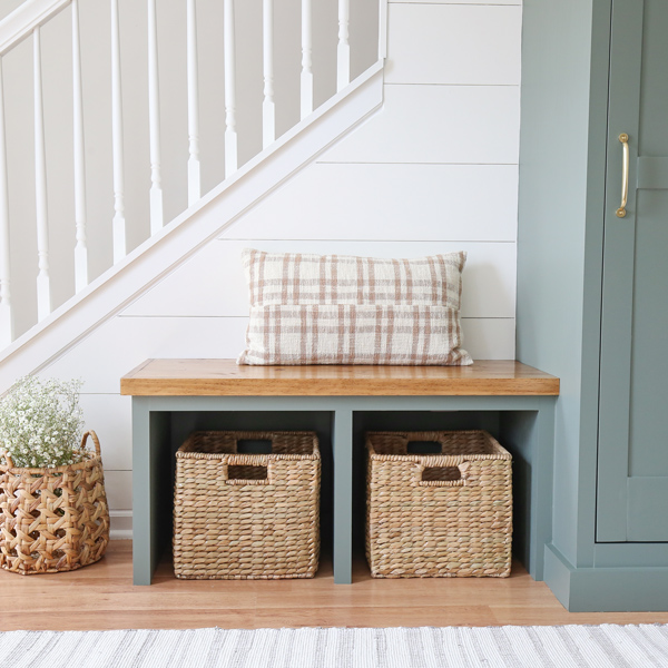 diy entryway bench with two seagrass baskets and DIY shiplap on angled wall