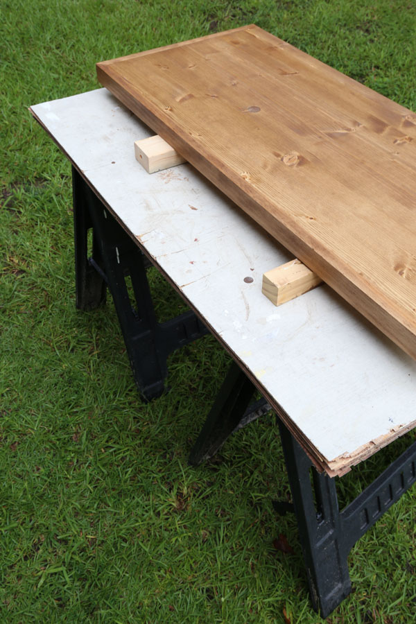 work space set up for applying polyurethane using sawhorses, plywood, and 2x wood under project