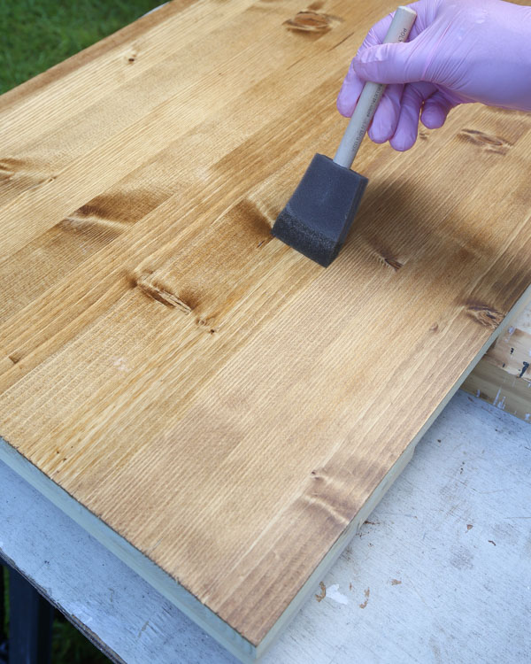 apply first coat of polyurethane in a long stroke into the grain of the wood with foam brush