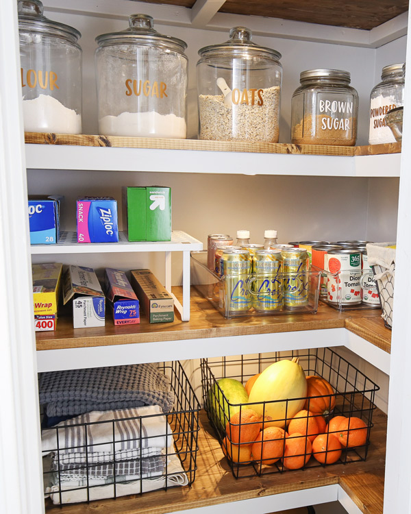DIY small corner pantry organization makeover with bins and baksets holding pantry items