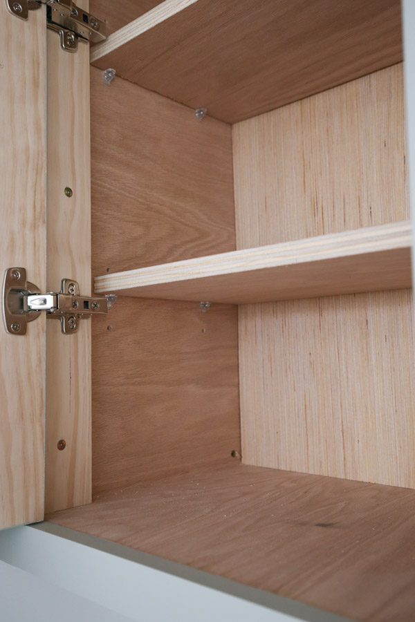 shelf peg holes drilled on inside of DIY cabinet