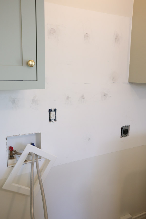 wall prepared for peel and stick tile with outlet covers removed