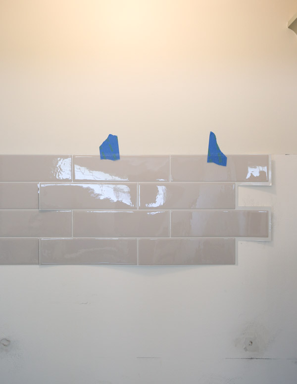 using painters tape to help install full sheet of peel and stick tile backsplash