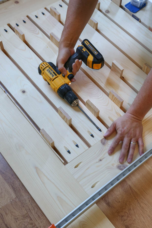 drilling kreg screws to slat boards to attach DIY outdoor patio table top together