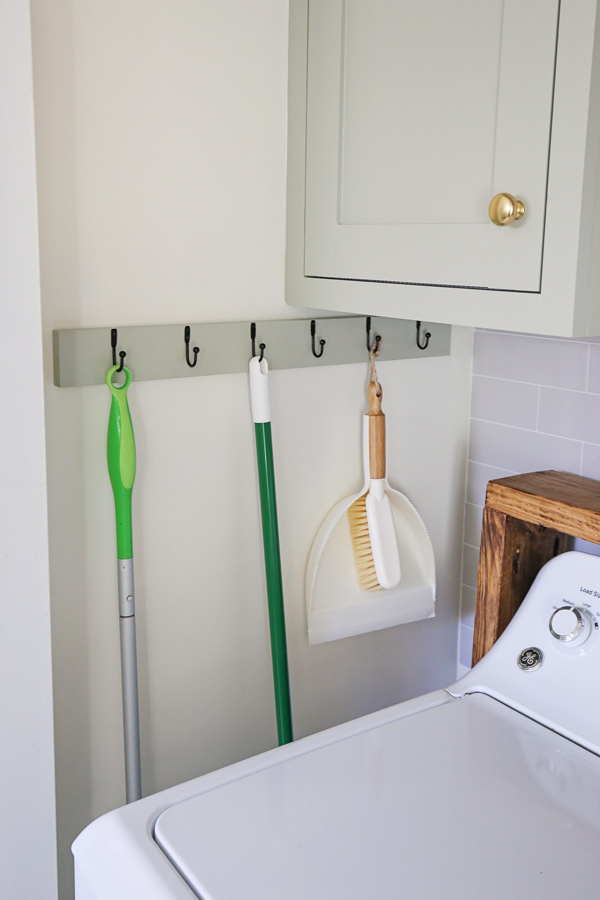 DIY wall rack for Swiffer, dust pan, and broom on laundry closet wall