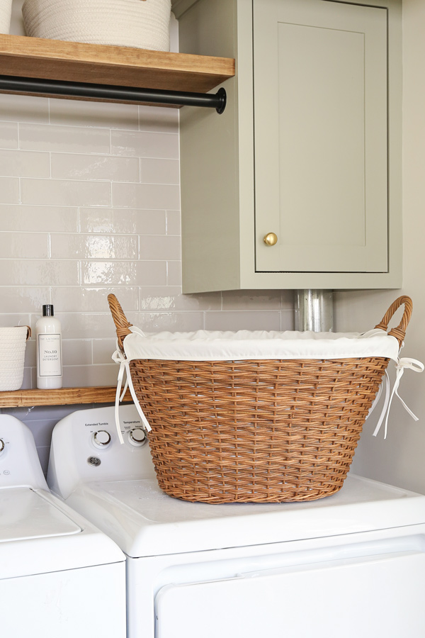 large wicker laundry basket with handles and liner in laundry room makeover