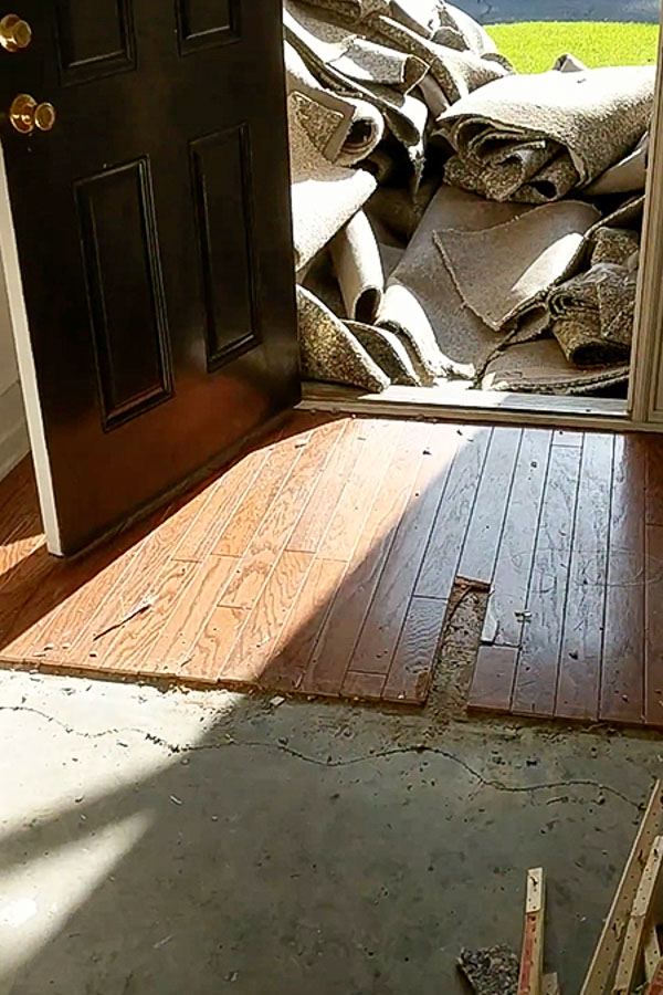 old entryway flooring and carpet torn out of house in doorway