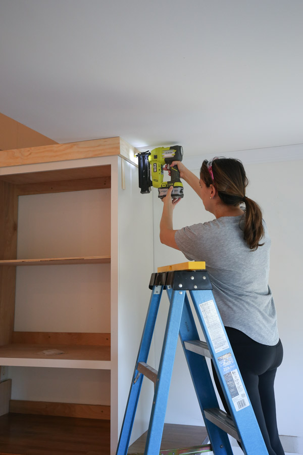 attaching top 1x4 trim to diy built in cabinet with brad nailer