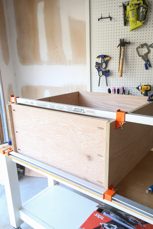 assembling bottom of cabinet frame to the sides with clamps