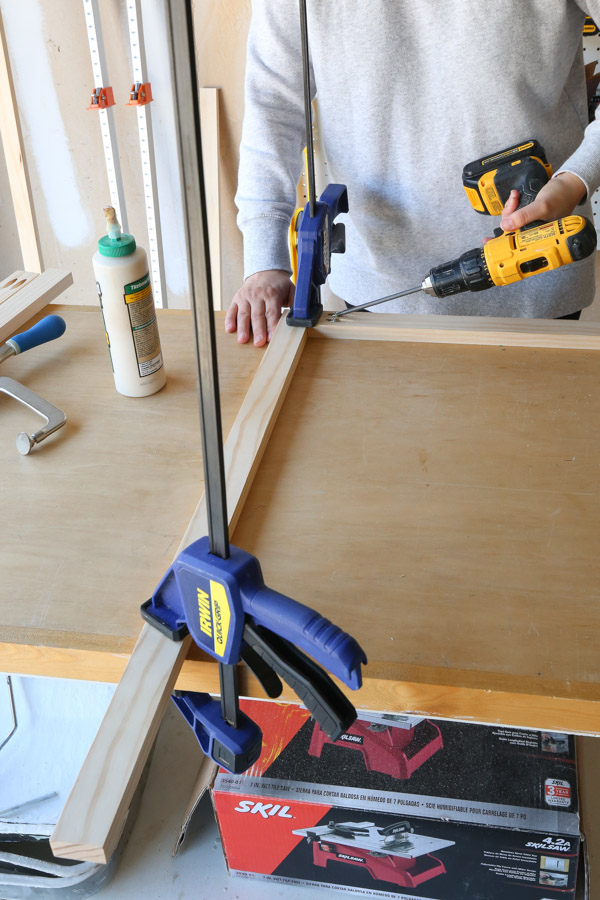 assembling the cabinet face frame together with drill, clamps, and kreg screws
