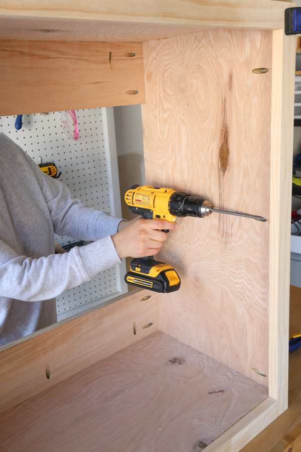 attaching the face frame to the garage cabinet with drill and screws in pocket holes