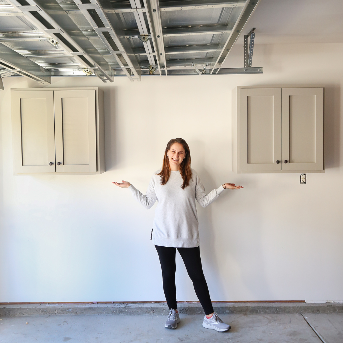 woman DIYer between two DIY garage cabinets