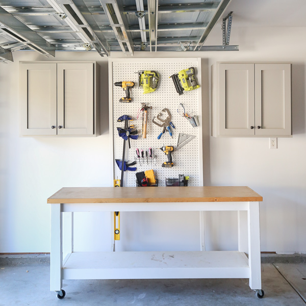 gray DIY garage cabinets with tool pegboard and workbench