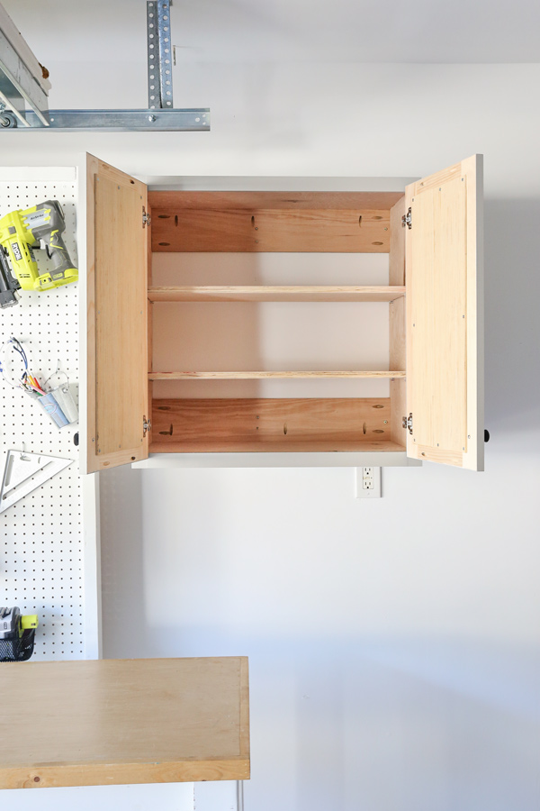 diy garage storage cabinet with doors open and two adjustable shelves