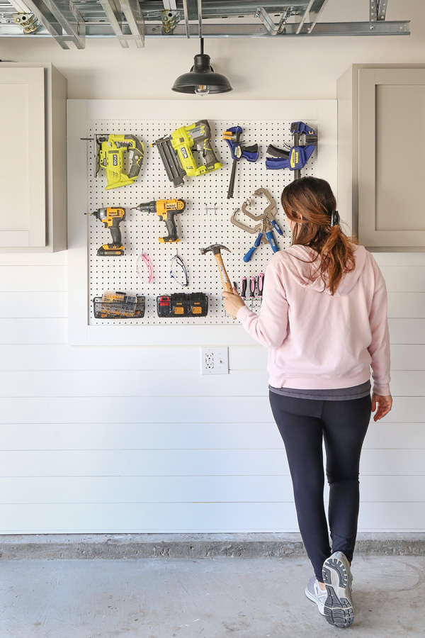 woman organizing DIY pegboard wall organizer