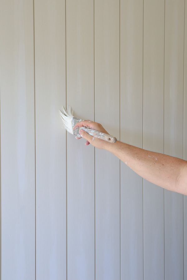 painting shiplap gaps with a paint brush