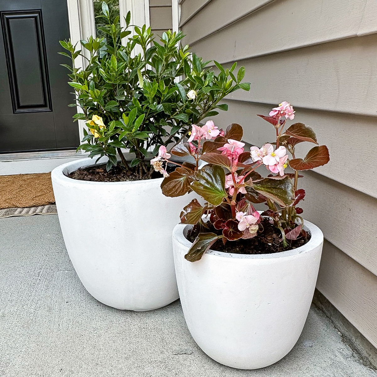 set of two, white, concrete outdoor planters on porch from amazon that are budget friendly