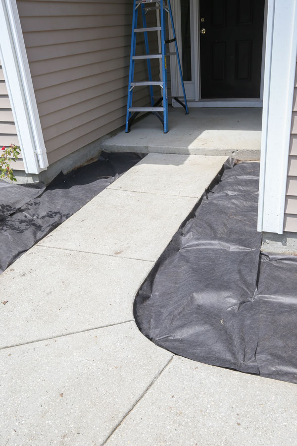 laying weed barrier in front of small front porch