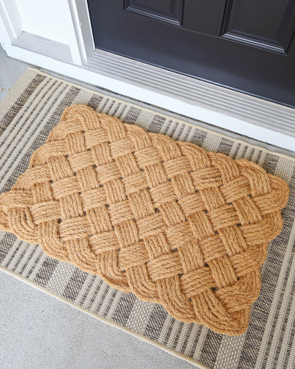 layered doormat on top of outdoor rug in front of front door