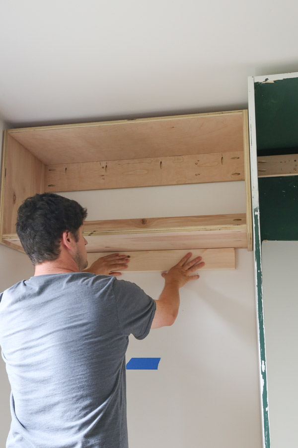 using a 2x4 support to help install DIY wall cabinet to wall for diy built in office cabinets