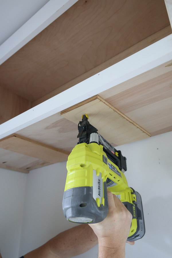attaching wood spacer blocking to bottom of the wall cabinet with brad nailer