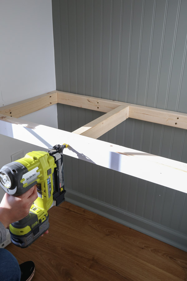 attaching the front trim with brad nailer to the DIY built in computer desk frame on wall