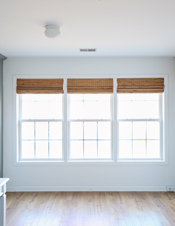 window makeover with trim between windows and bamboo blinds