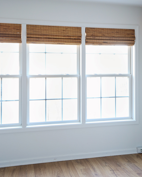 window makeover with DIY window trim between two windows and bamboo blinds
