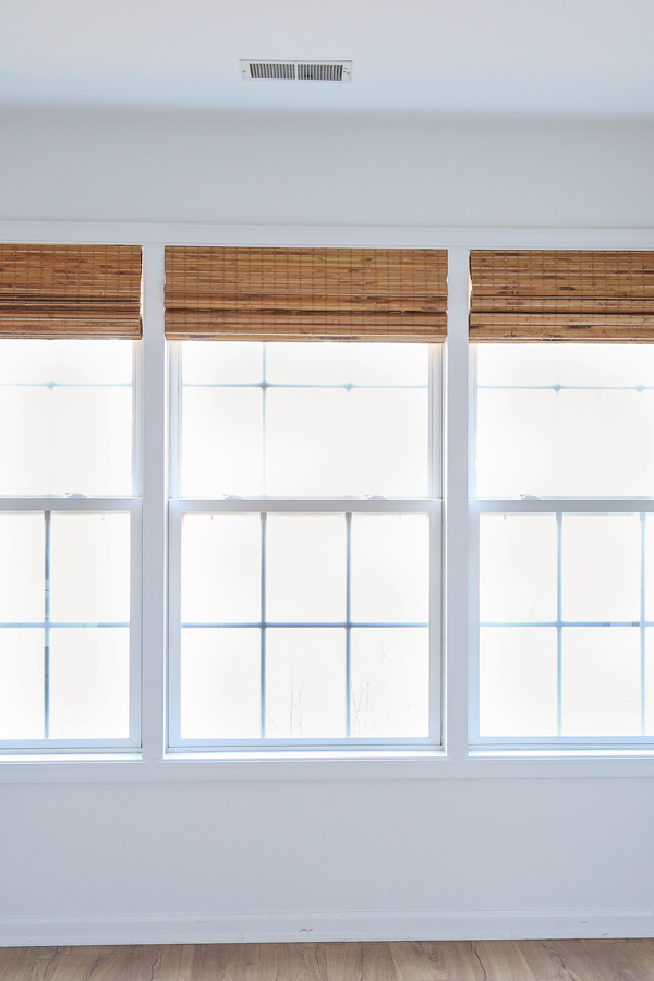 window makeover with DIY window trim between windows and bamboo blinds from amazon