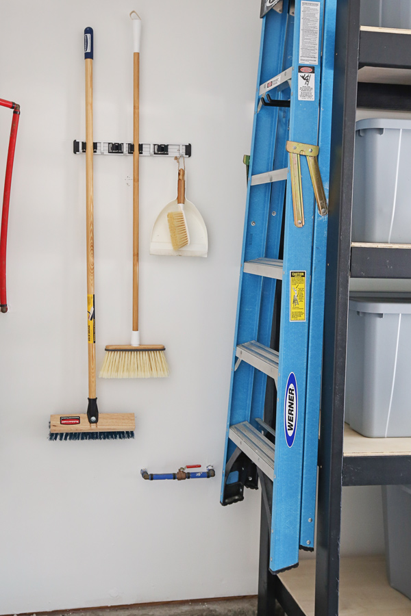 wall broom holder with brooms and ladder on DIY garage shelves for diy garage storage