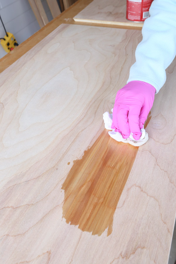 applying pre-stain wood conditioner to birch plywood with rag before staining