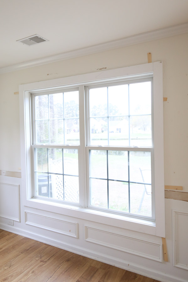 1x4 trim boards installed around window with wood shims for DIY window trim interiors