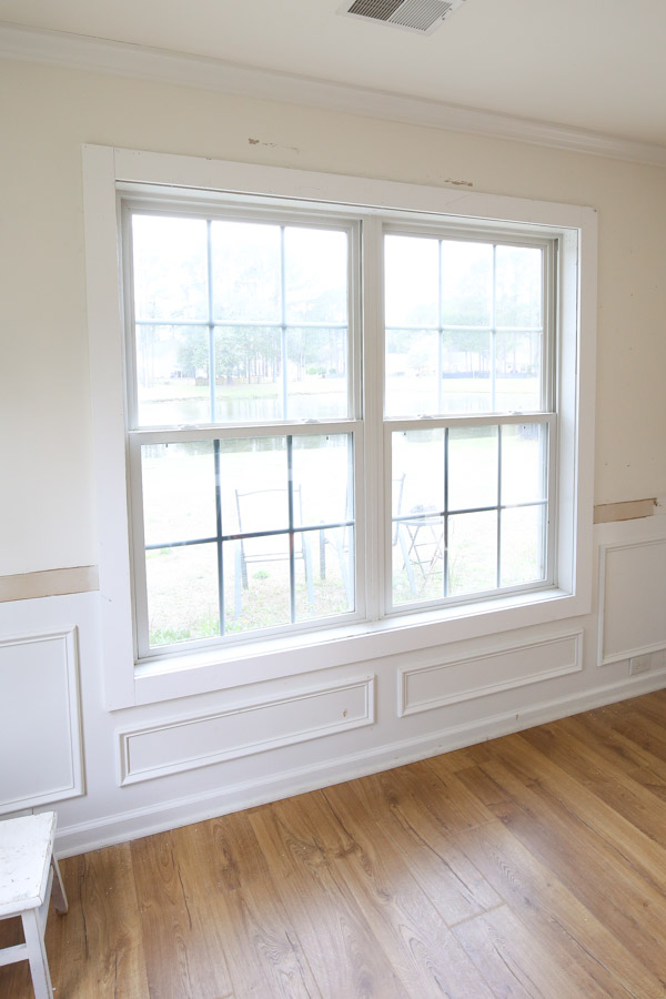 1x4 trim boards installed around window with wood shims for DIY minimalist window trim