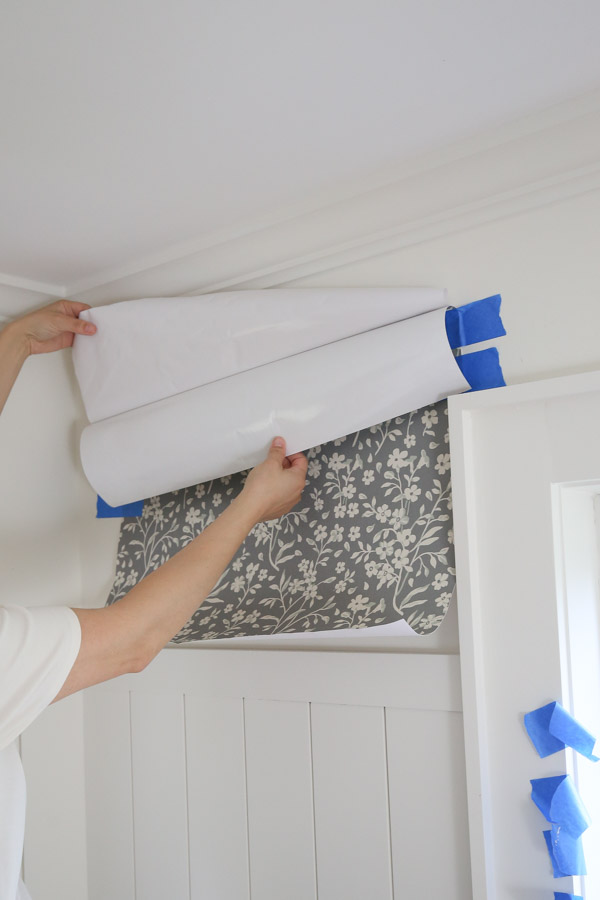 pulling backing paper away for peel and stick wallpaper diy