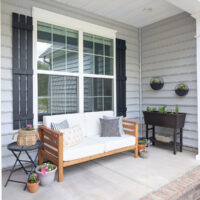 spring porch makeover with outdoor couch, planters, wall planters, and raised garden bed