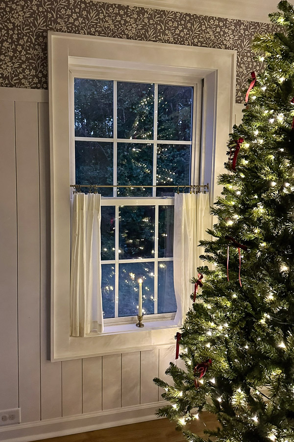 candle Christmas window in dining room window with cafe curtains and charming vintage candle holder and flameless candles