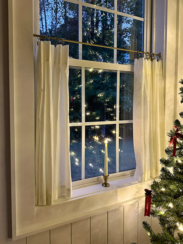 candle Christmas window in dining room window with cafe curtains and charming vintage candle holder and flameless candles