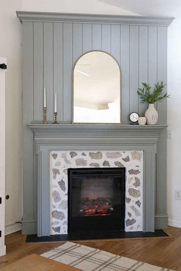 DIY shiplap fireplace with a faux stone fireplace DIY surround in living room with mirror on mantel