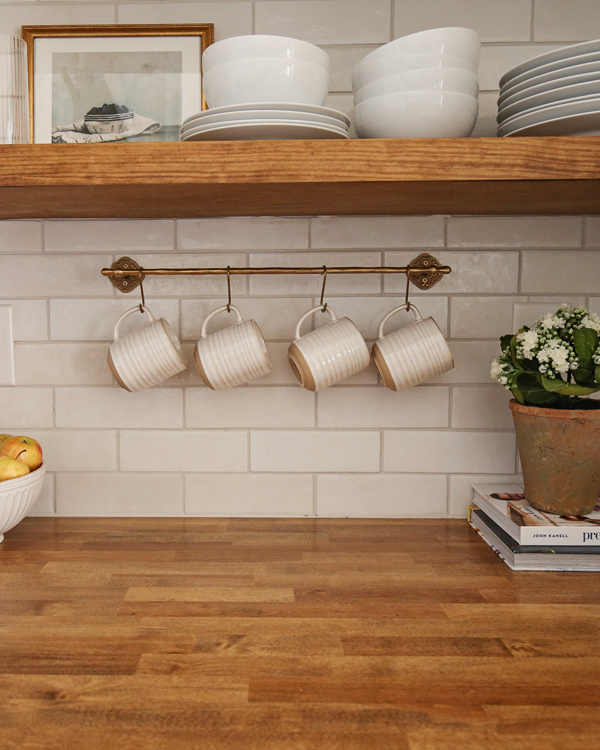 kitchen makeover with diy kitchen floating shelf and brass kitchen rail with mugs