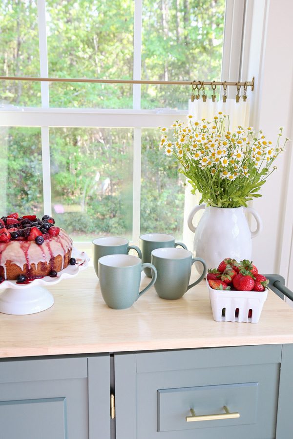 mobile kitchen cart in dining room for entertaining with cake and food and mug set