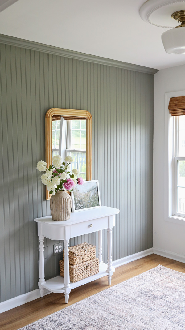 charming office wall decor ideas with vintage inspired console table, wood arch mirror, baskets, framed art, and handcrafted vase