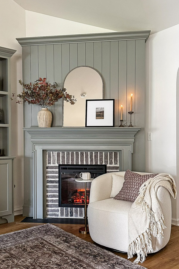 cozy fall fireplace decor and fall fireplace sitting area with swivel chair, mirror, fall pillow, fall stems