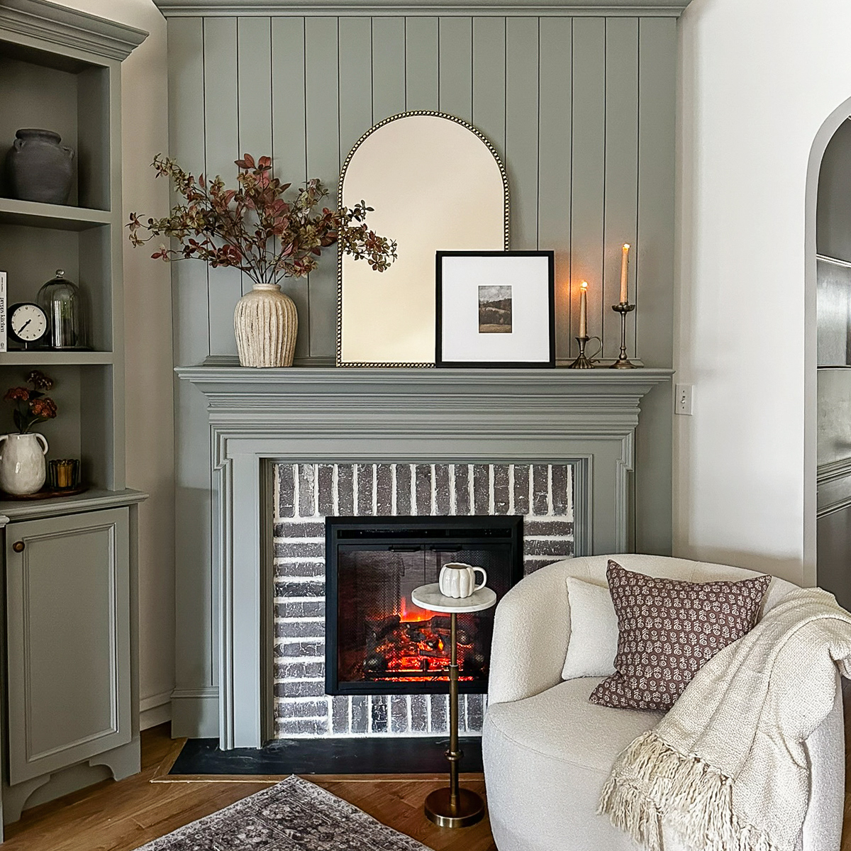 cozy fall fireplace decor and fall fireplace sitting area with swivel chair, mirror, fall pillow, fall stems