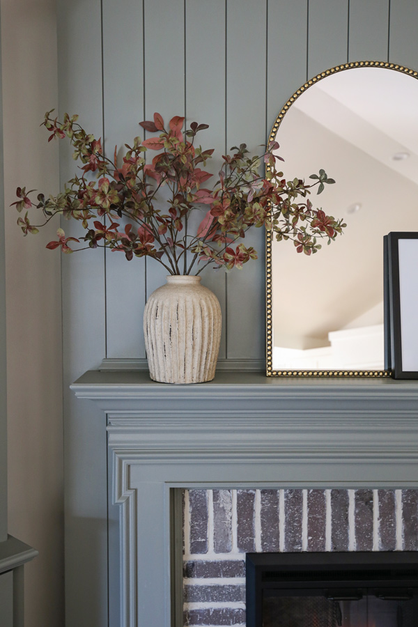 fall stems on fireplace mantel in distressed vase