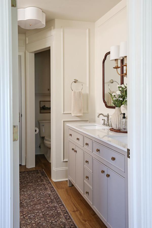 primary bathroom makeover with flush mount ceiling light and regina andrew clove wall sconce