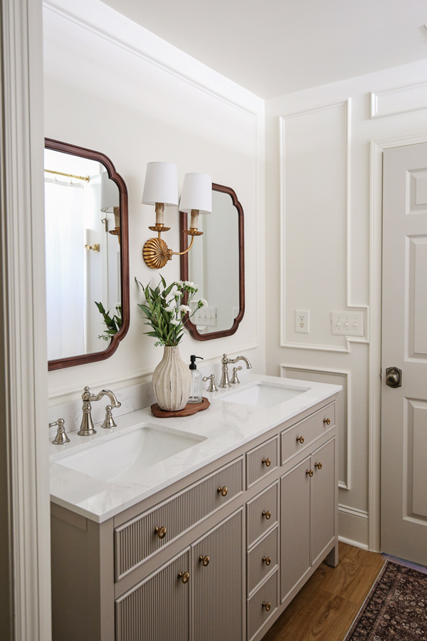 timeless, charming, classic, vintage look bathroom makeover with double wall sconce, and wood arch mirrors and polished nickel faucet