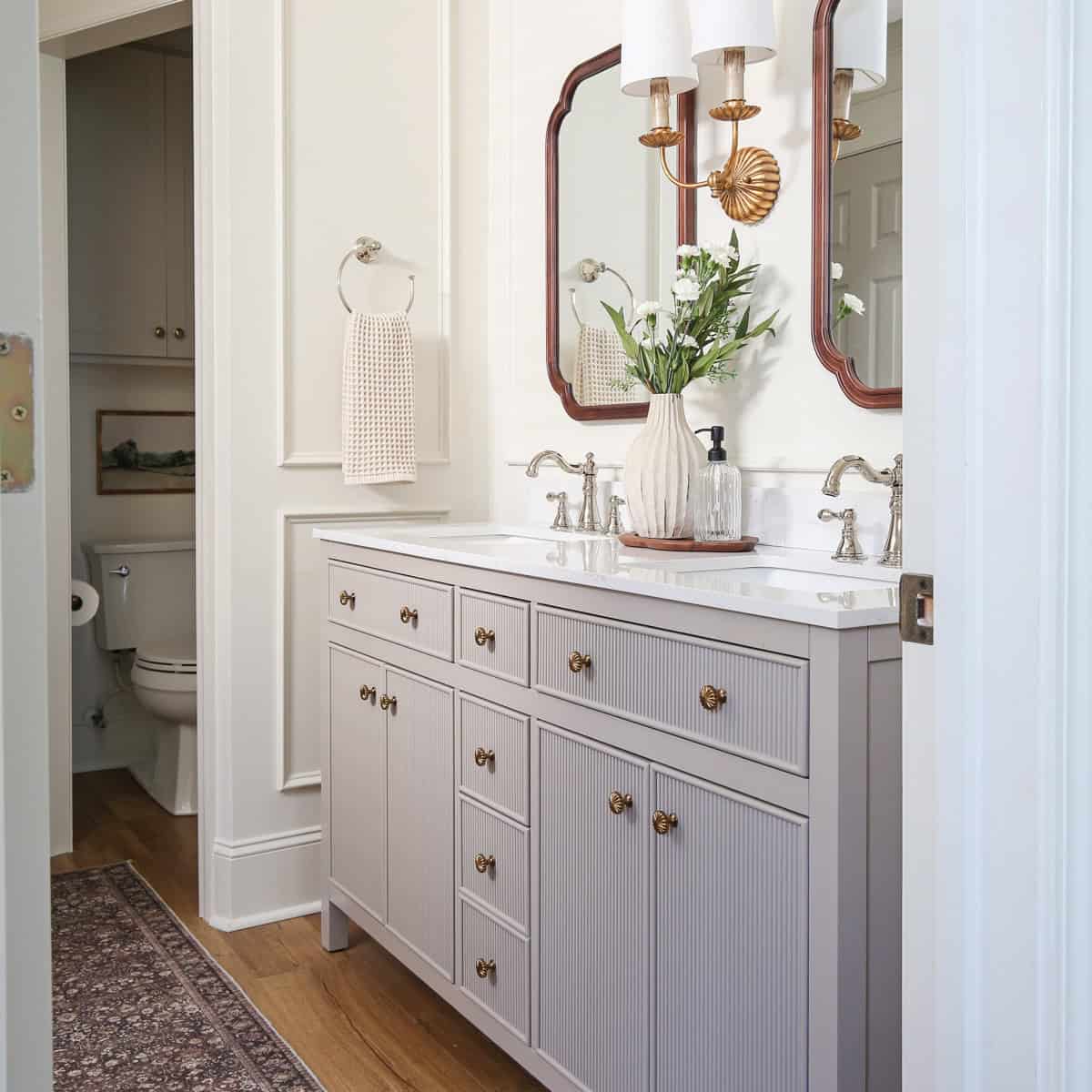 timeless, charming, classic, vintage look bathroom makeover with double wall sconce, and wood arch mirrors and polished nickel faucet