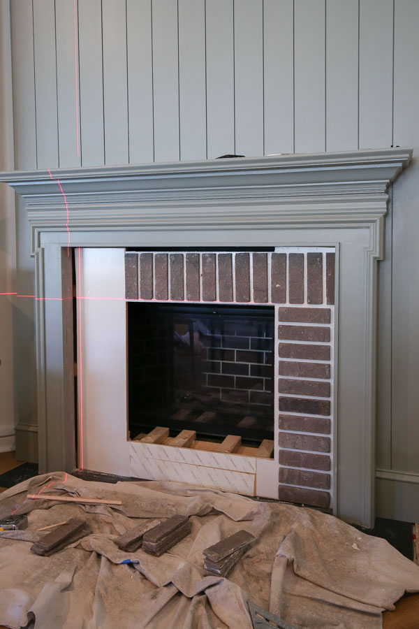 applying bricks to brick fireplace DIY